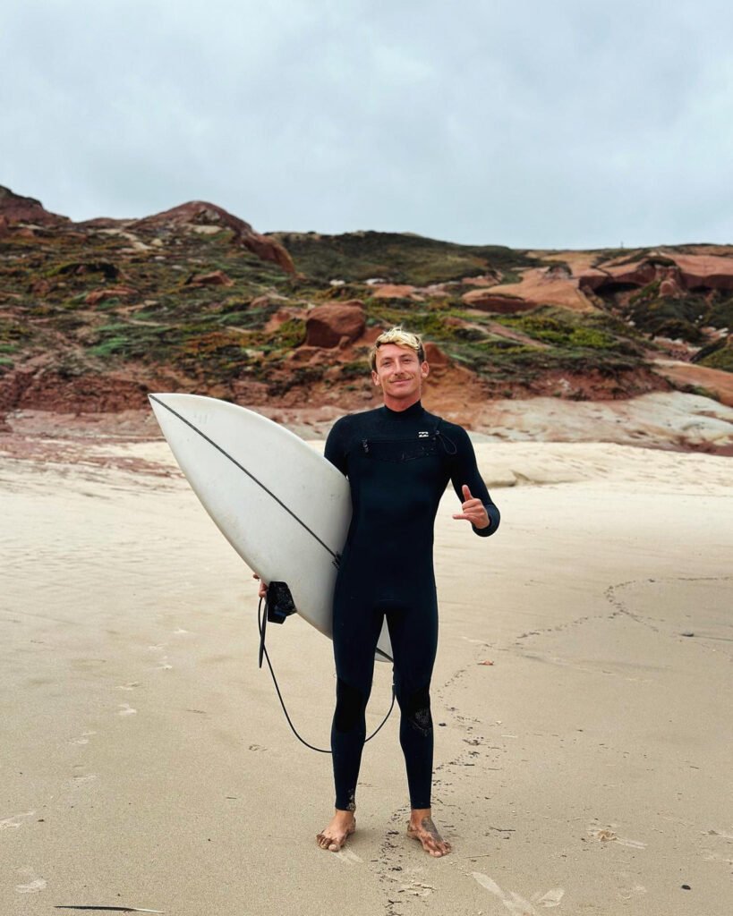 hugo avec un surf sur la plage